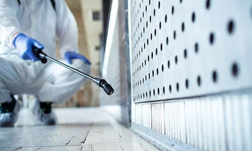 personnel qui désinfecte en tenue